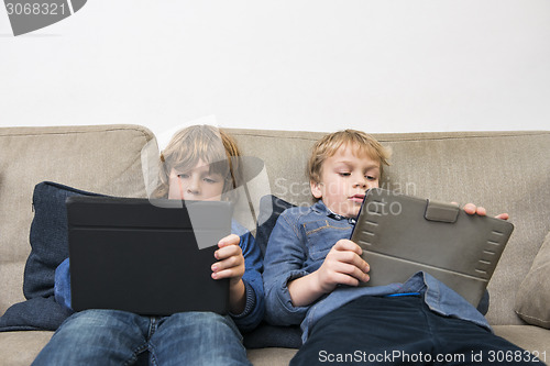 Image of Boys Using Digital Tablets On Sofa