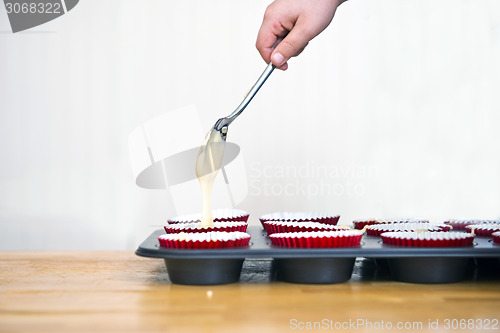 Image of Filling cupcakes with batter