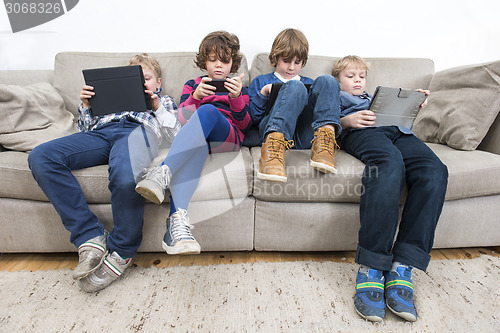 Image of Brothers And Sister Using Technologies On Sofa