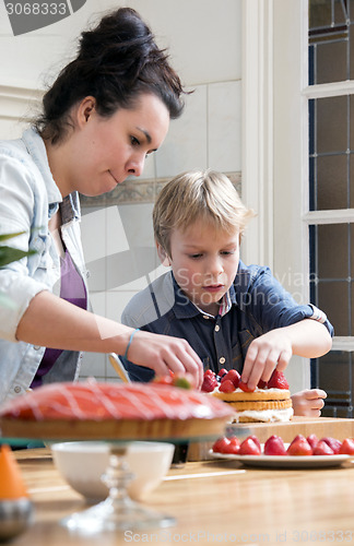 Image of Mother And Son Preparing Cake In Kitchen