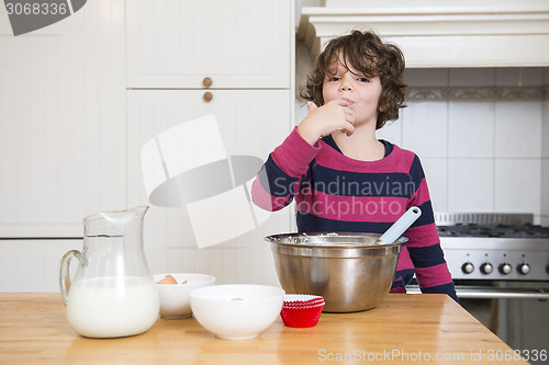 Image of Girl Licking Batter While Preparing Cupcake