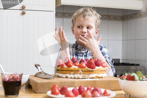 Image of Boy Licking Finger with Strawberry Cake batter behind a kitchen 