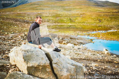 Image of Man Sitting On Stone In Norwegian Mountains