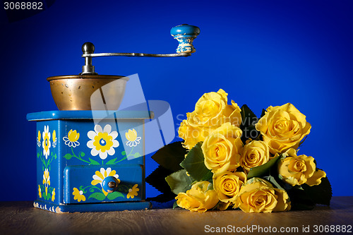 Image of Blue coffee grinder and roses