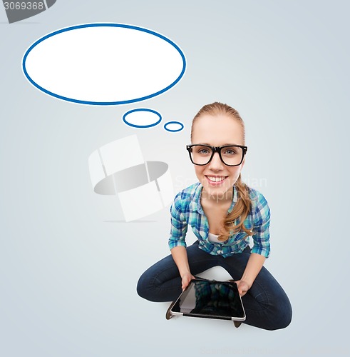 Image of smiling teen girl sitting on floor with tablet pc