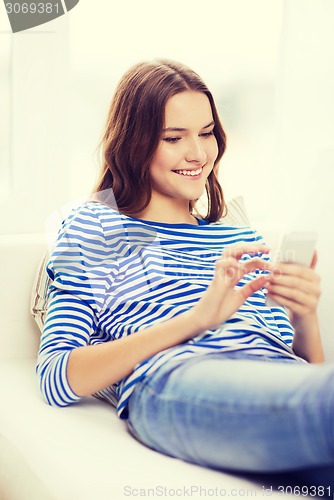 Image of smiling teenage girl with smartphone at home