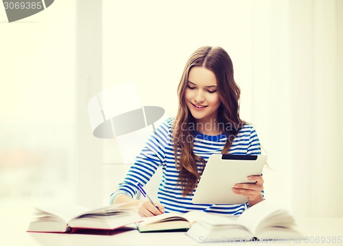 Image of smiling student girl with tablet pc and books