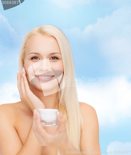 Image of woman applying cream on her skin