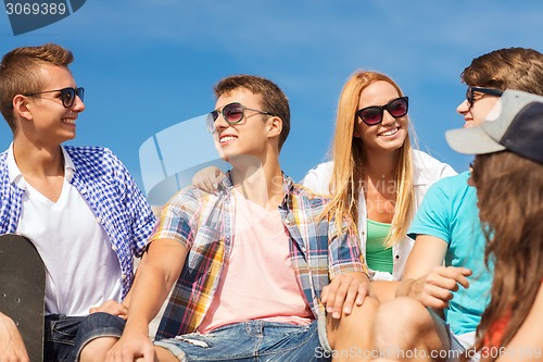 Image of group of smiling friends sitting on city street