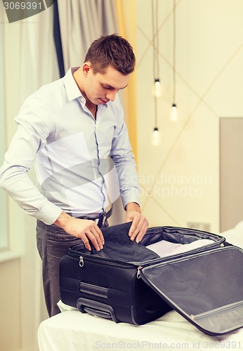 Image of businessman packing things in suitcase