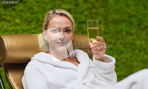 Image of beautiful young woman drinking champagne at spa