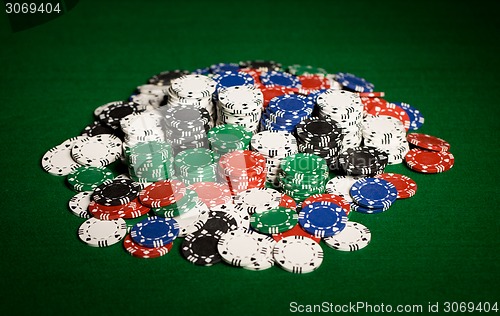 Image of close up of casino chips on green table surface