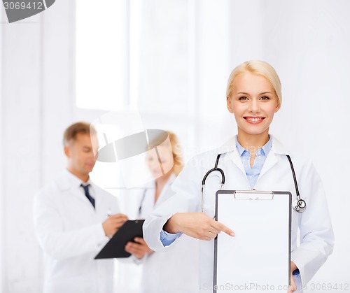 Image of smiling female doctor with clipboard