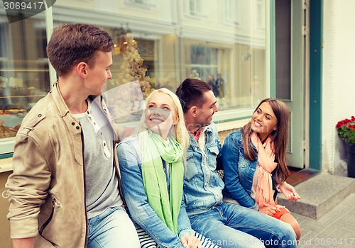 Image of group of smiling friends walking in the city