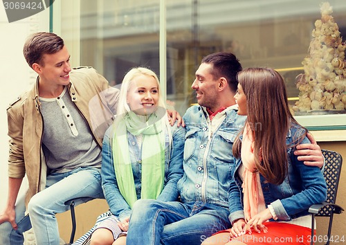 Image of group of smiling friends walking in the city