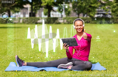 Image of smiling woman with tablet pc outdoors