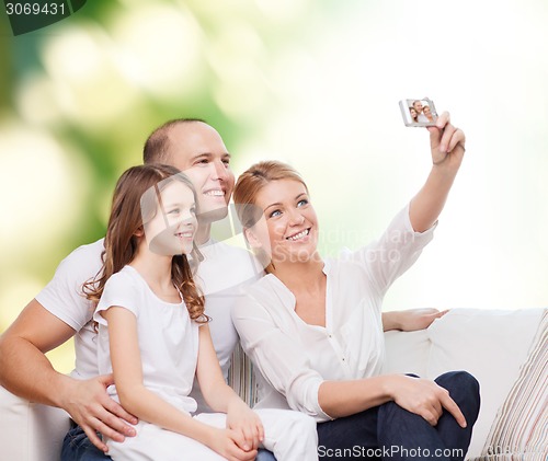 Image of happy family with camera at home