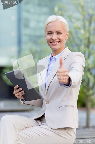 Image of smiling businesswoman with tablet pc outdoors