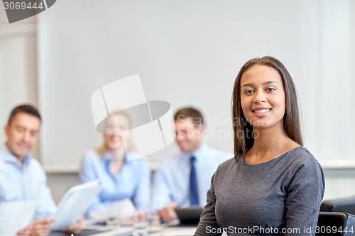 Image of group of smiling businesspeople meeting in office