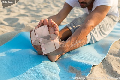 Image of close up of man making yoga exercises outdoors