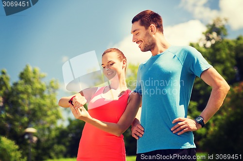 Image of smiling people with heart rate watches outdoors