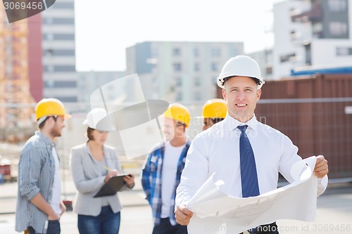 Image of group of builders with tablet pc and blueprint