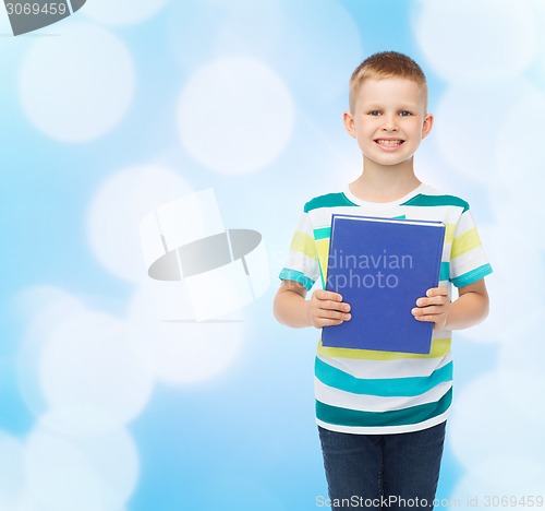 Image of smiling little student boy with blue book