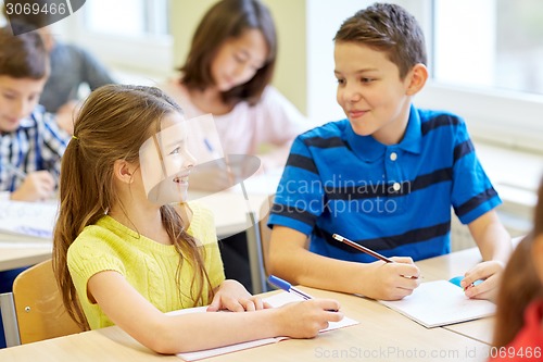 Image of group of school kids writing test in classroom