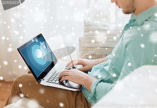 Image of close up of man working with laptop at home