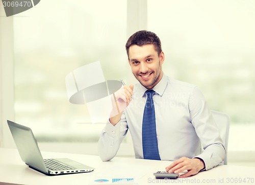 Image of smiling businessman with laptop and documents