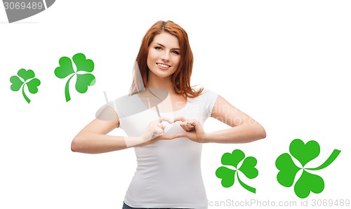 Image of smiling girl showing heart gesture with shamrock