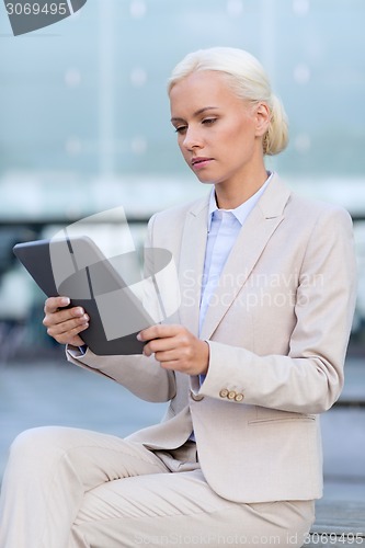 Image of businesswoman working with tablet pc outdoors