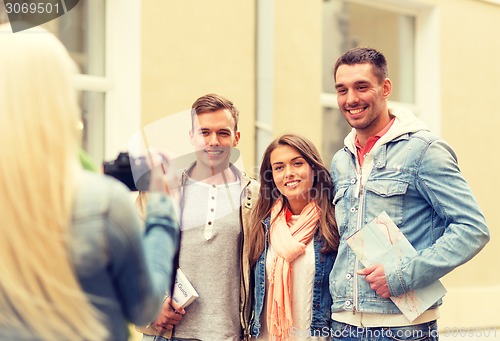Image of group of smiling friends taking photo outdoors
