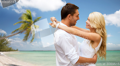Image of happy couple hugging over beach background