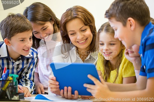 Image of group of kids with teacher and tablet pc at school