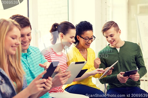 Image of smiling students with tablet pc at school