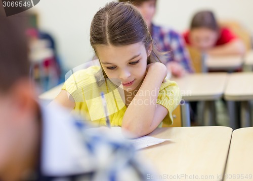 Image of group of school kids writing test in classroom