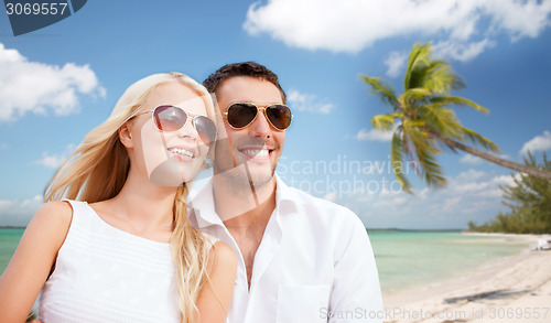 Image of couple in shades over tropical beach background
