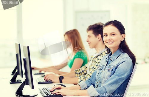Image of three smiling students in computer class