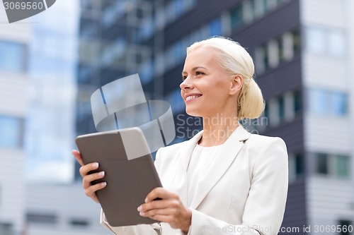 Image of smiling businesswoman with tablet pc outdoors