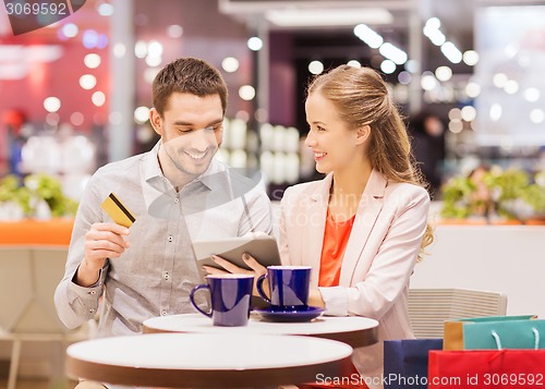 Image of couple with tablet pc and credit card in mall