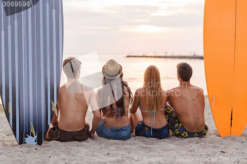 Image of group of friends in sunglasses with surfs on beach