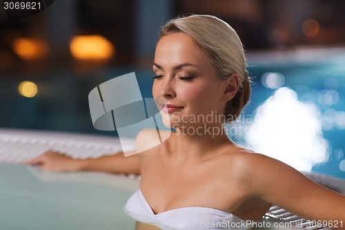 Image of happy womani sitting in jacuzzi at poolside