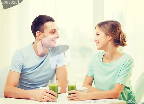 Image of smiling couple having breakfast at home