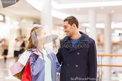 Image of happy young couple with shopping bags in mall