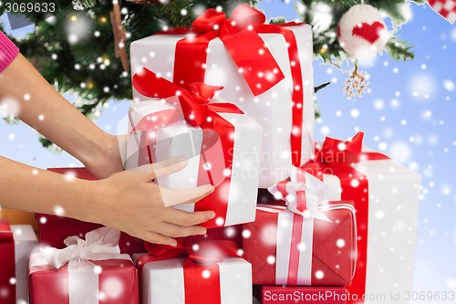 Image of close up of woman with gifts and christmas tree
