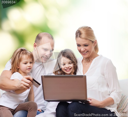 Image of happy family with laptop computer and credit card