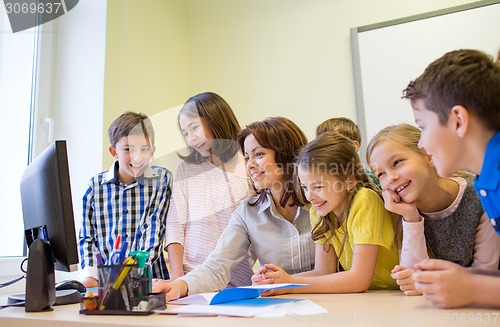 Image of group of kids with teacher and computer at school