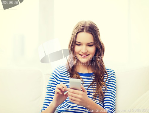 Image of smiling teenage girl with smartphone at home