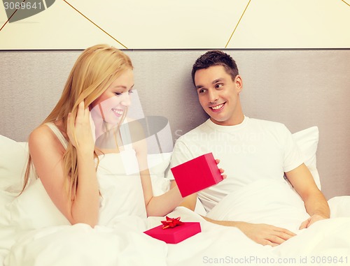 Image of man giving woman little red gift box